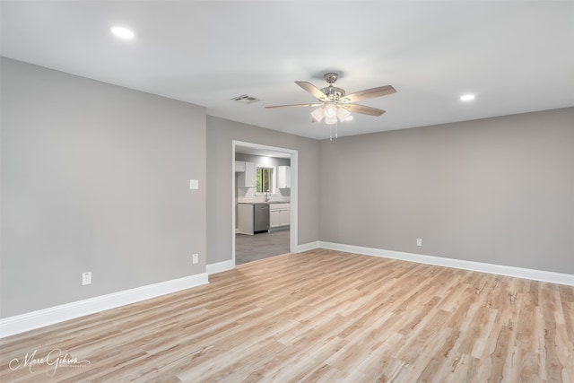 empty room with ceiling fan and light wood-type flooring