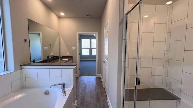 bathroom with vanity, hardwood / wood-style flooring, and independent shower and bath