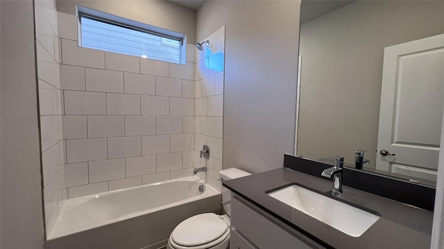 full bathroom with tiled shower / bath, vanity, and toilet