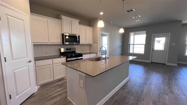 kitchen featuring pendant lighting, white cabinetry, an island with sink, sink, and stainless steel appliances