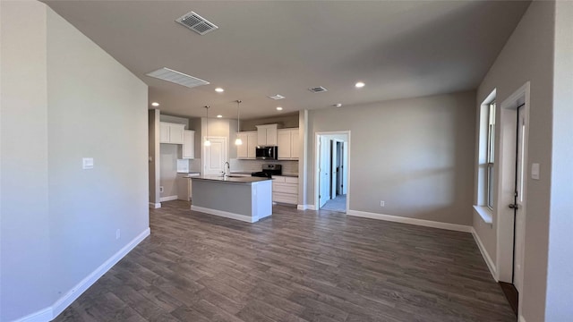 kitchen with white cabinetry, decorative light fixtures, appliances with stainless steel finishes, and a center island with sink