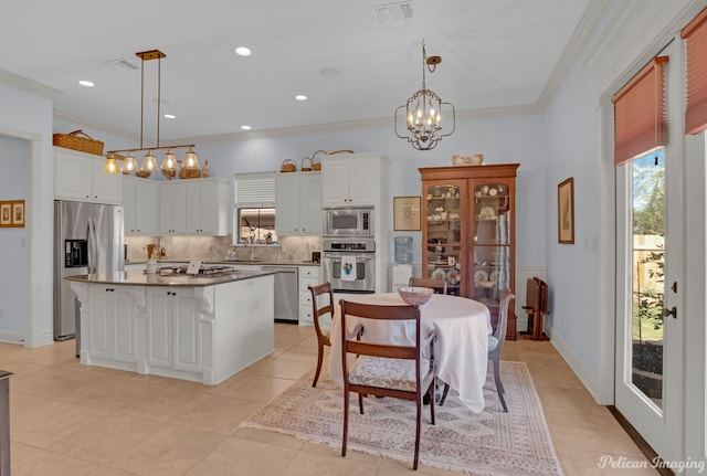 kitchen featuring hanging light fixtures, appliances with stainless steel finishes, a center island, and white cabinets