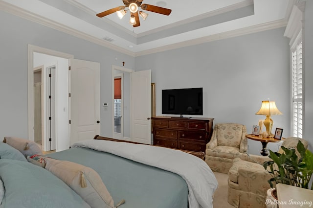 bedroom with ceiling fan, ornamental molding, and a tray ceiling