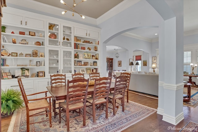 dining space featuring hardwood / wood-style flooring, crown molding, and a notable chandelier