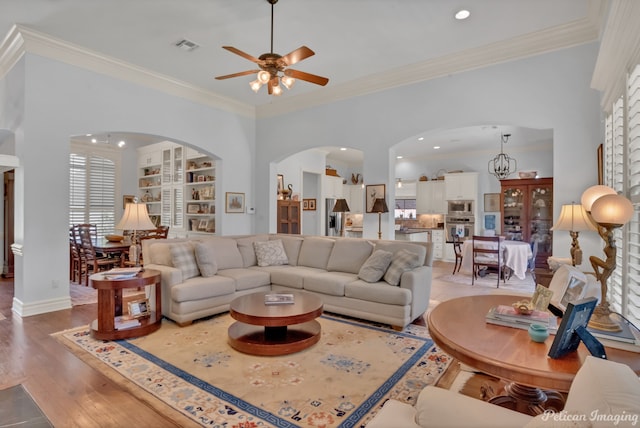 living room with ornamental molding, hardwood / wood-style floors, and built in shelves