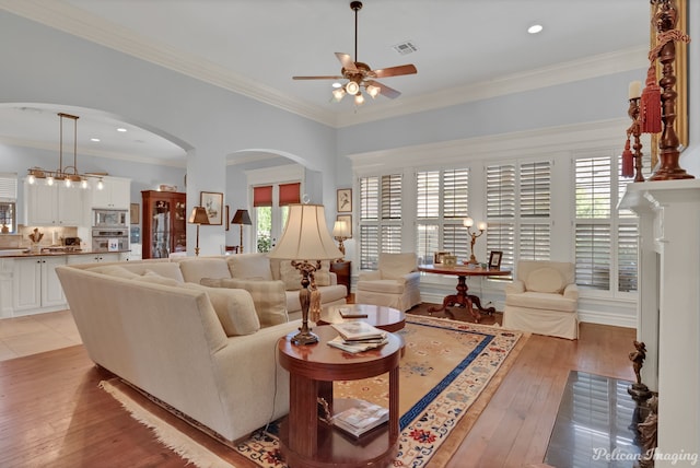 living room with crown molding, ceiling fan, and light hardwood / wood-style flooring