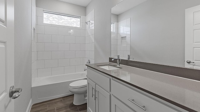 full bathroom featuring tiled shower / bath combo, vanity, and toilet