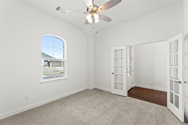 spare room featuring vaulted ceiling, carpet floors, ceiling fan, and french doors