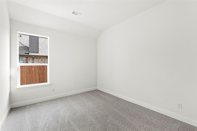 carpeted spare room with lofted ceiling