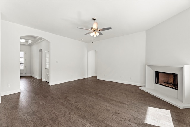 unfurnished living room with dark hardwood / wood-style flooring and ceiling fan