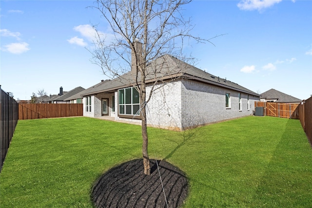 3121 Blue Hl, Burleson, TX 76028 - back of house featuring brick siding, a fenced backyard, a lawn, and central AC