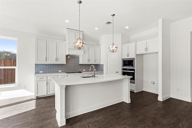 kitchen featuring sink, a center island with sink, white cabinets, and black appliances