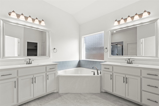 bathroom with vanity, vaulted ceiling, and independent shower and bath