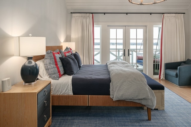 bedroom with multiple windows, hardwood / wood-style floors, access to outside, and french doors