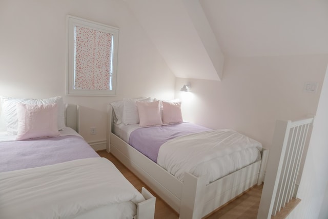 bedroom with vaulted ceiling and light wood-type flooring