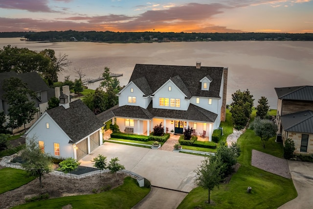 aerial view at dusk featuring a water view