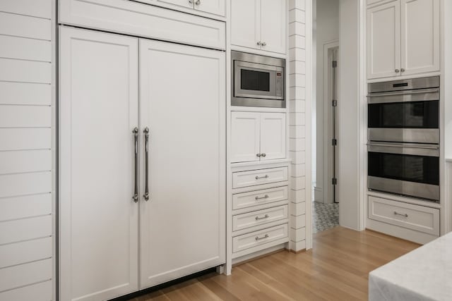 kitchen featuring white cabinetry, stainless steel appliances, and light wood-type flooring