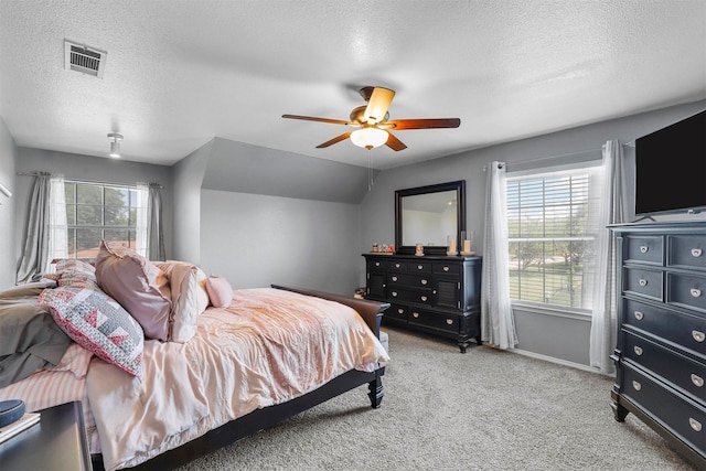 carpeted bedroom featuring lofted ceiling, a textured ceiling, and ceiling fan