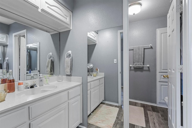 bathroom with vanity, toilet, and hardwood / wood-style floors