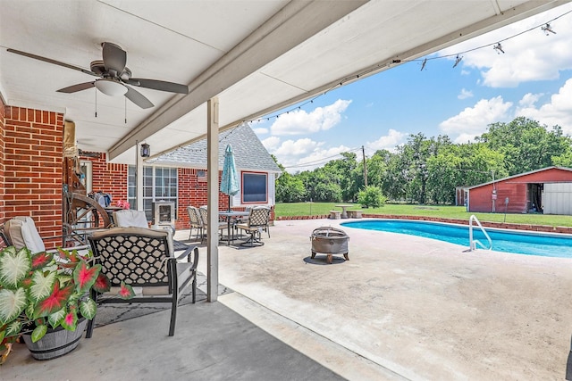 view of patio with a storage shed, a fenced in pool, and a fire pit