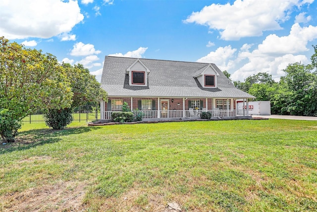 new england style home featuring a porch and a front lawn