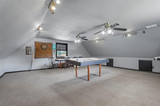 rec room with lofted ceiling, rail lighting, light carpet, and a textured ceiling