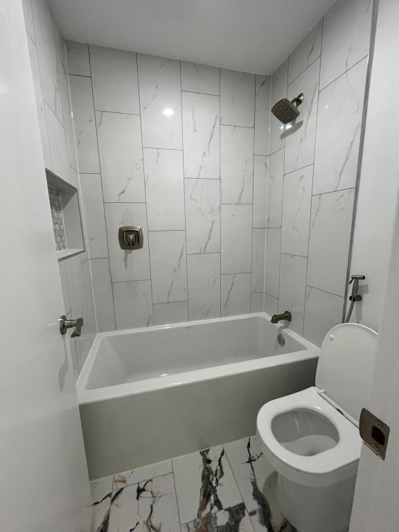 bathroom with tiled shower / bath and toilet