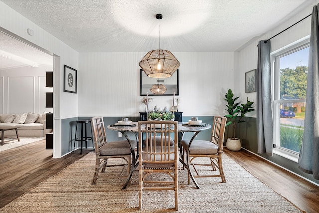 dining room with dark wood-type flooring and a textured ceiling