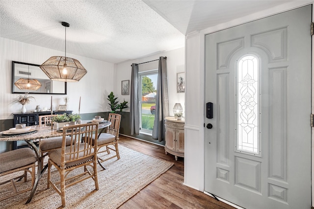 dining space with hardwood / wood-style flooring and a textured ceiling