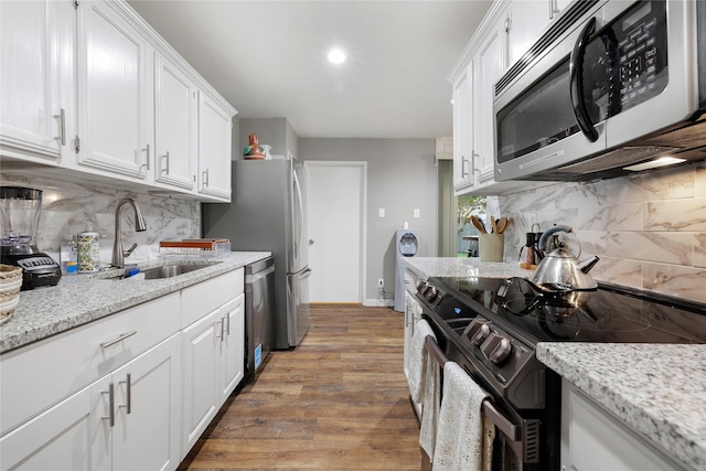 kitchen featuring sink, light hardwood / wood-style floors, white cabinets, and appliances with stainless steel finishes