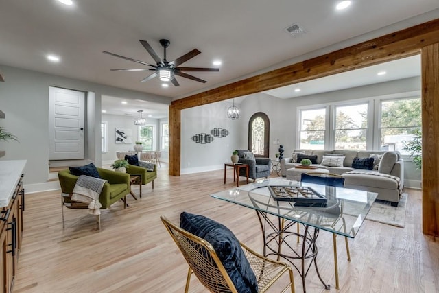 living room featuring ceiling fan with notable chandelier and light hardwood / wood-style floors