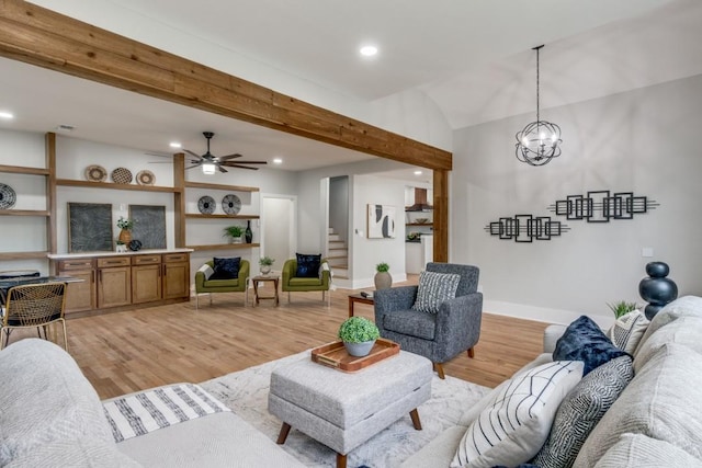 living room with lofted ceiling with beams, ceiling fan with notable chandelier, and light hardwood / wood-style floors