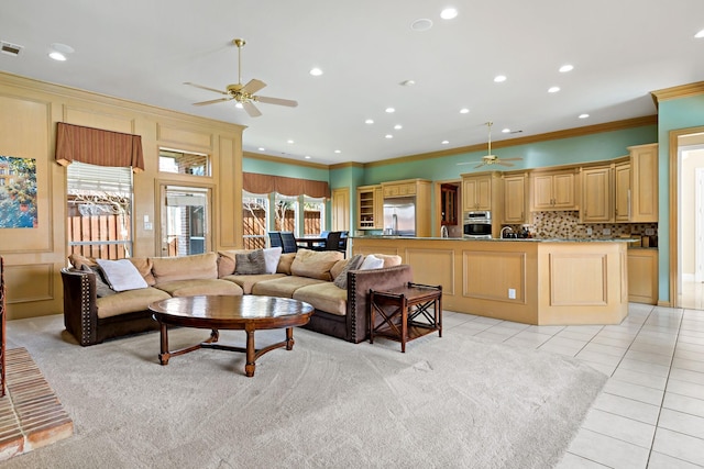 living room with crown molding, light tile patterned floors, and ceiling fan