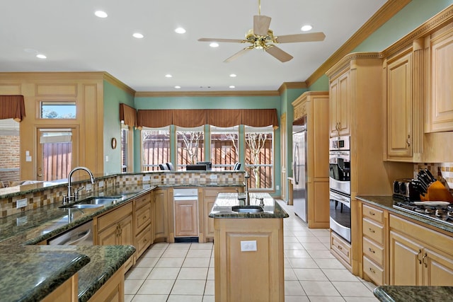 kitchen with a center island, sink, light brown cabinets, and dark stone counters