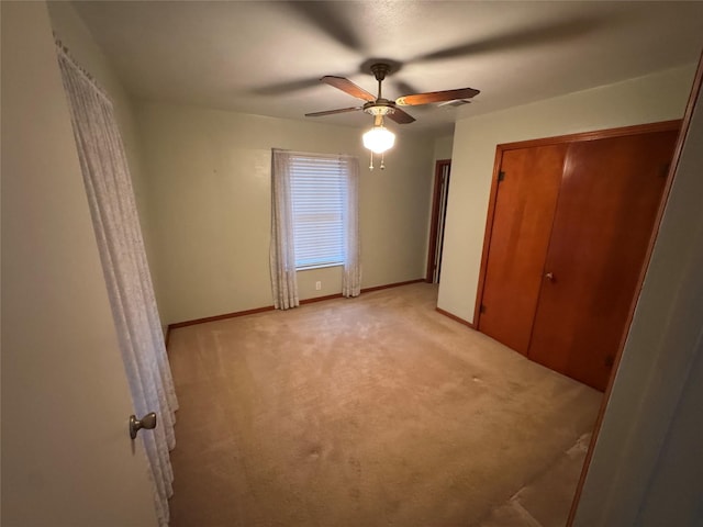 unfurnished bedroom featuring ceiling fan and light carpet