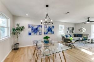 dining space with a wealth of natural light, a notable chandelier, and light hardwood / wood-style floors