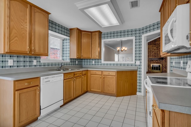 kitchen with sink, hanging light fixtures, light tile patterned floors, a notable chandelier, and white appliances