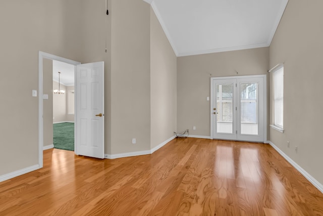 empty room with crown molding, a notable chandelier, and light hardwood / wood-style floors