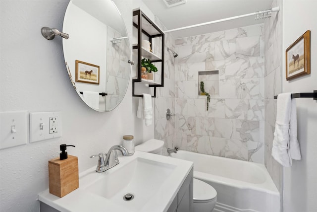 full bathroom featuring vanity, tiled shower / bath combo, and toilet