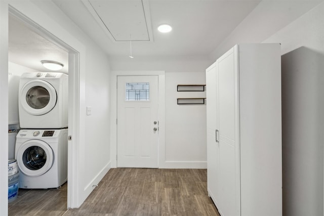 laundry room with stacked washing maching and dryer and wood-type flooring