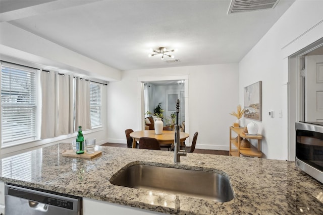 kitchen featuring stone counters, appliances with stainless steel finishes, sink, and white cabinets