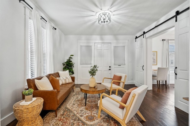 sitting room featuring a barn door and dark hardwood / wood-style flooring