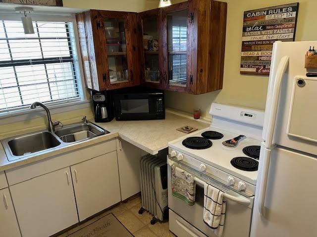 kitchen with white cabinetry, sink, and white appliances