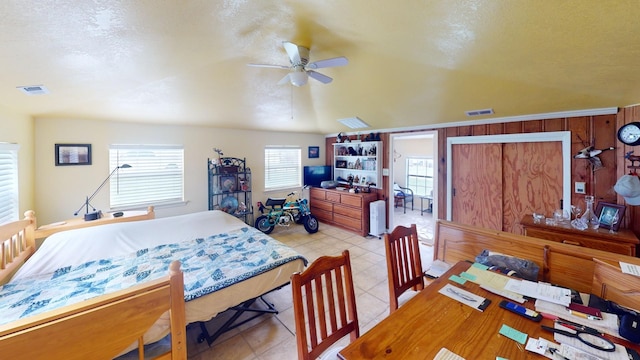 bedroom featuring ceiling fan and wood walls