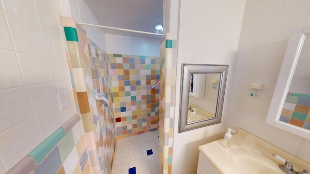 bathroom with vanity, a shower with shower curtain, and tile walls