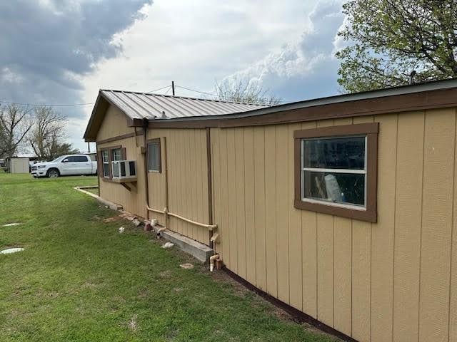 view of home's exterior featuring cooling unit and a lawn