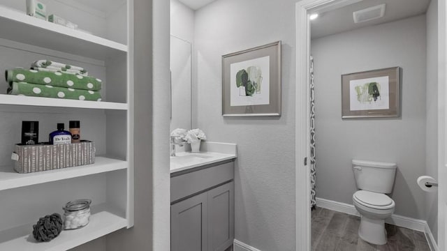 bathroom with vanity, toilet, and built in features