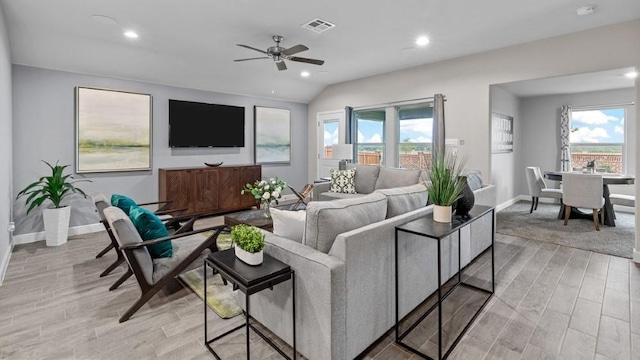 living room featuring vaulted ceiling, a healthy amount of sunlight, and ceiling fan