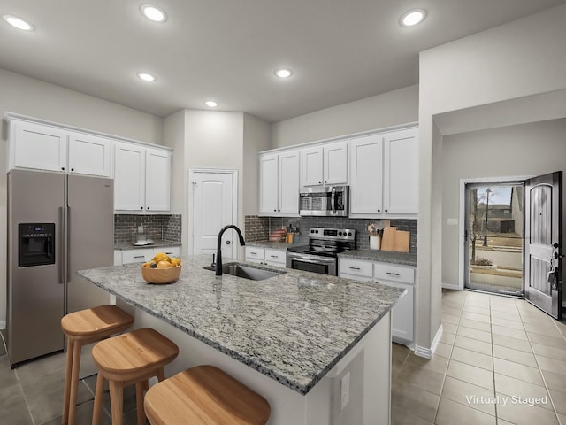 kitchen featuring sink, an island with sink, white cabinets, and appliances with stainless steel finishes