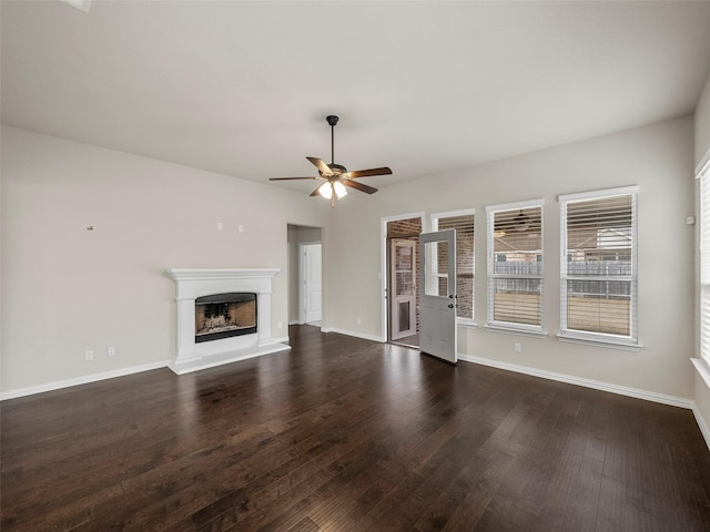 unfurnished living room featuring ceiling fan and dark hardwood / wood-style flooring